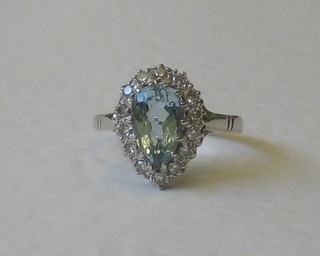 A 15ct white gold dress ring set a tear cut aquamarine supported by diamonds