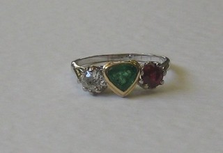 An 18ct white gold dress ring set a diamond, a heart shaped emerald and a ruby