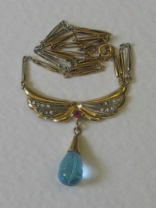 A gold necklet hung a panel inset diamonds and rubies with blue pendant