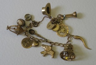A gold curb link charm bracelet with padlock clasp hung 15 charms