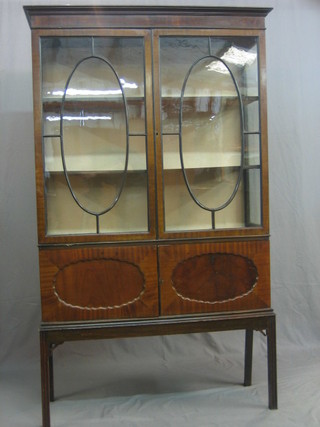 An Edwardian mahogany display cabinet, fitted adjustable shelves enclosed by astragal glazed panelled doors, raised on square tapering supports 41"