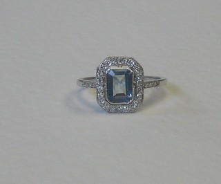 A lady's 18ct white gold dress ring set a lozenge cut aquamarine surrounded by numerous diamonds