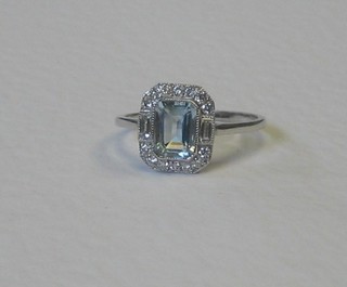 A lady's 18ct white gold dress ring set a lozenge cut aquamarine surrounded by numerous diamonds