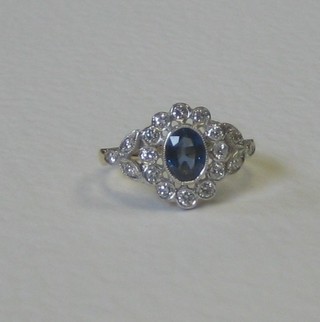 A lady's 18ct yellow gold dress ring set an oval cut sapphire surrounded by numerous diamonds, approx 0.55/0.90ct