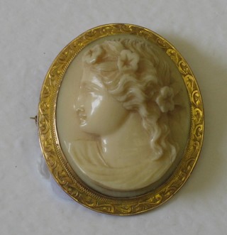 A carved ivory portrait brooch in the form of a lady contained in a gilt metal mount