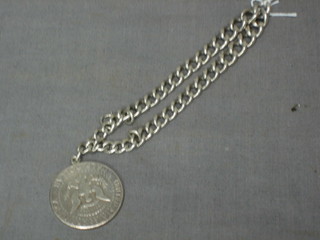 A silver curb link bracelet hung a 1964 half dollar