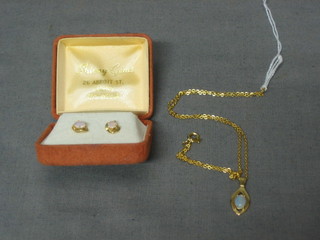 A gilt metal framed pendant set an opal and a pair of matching earrings