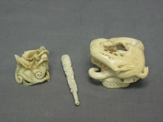 A carved ivory cigarette holder, a circular carved ivory sculpture of a snake 2" and a small grass hopper (3)
