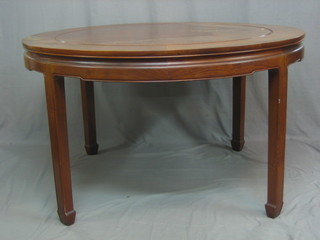 An Oriental Padouk wood dining suite comprising circular a dining table and 6 high back chairs raised on square supports