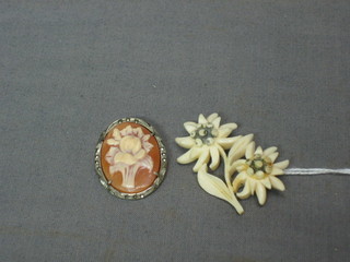 A tie pin set a red stone, a small shell carved cameo brooch and a small carved ivory brooch
