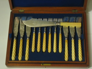 A 24 piece canteen of silver plated fish knives and forks with carved ivory handles and an associated fish server contained in a walnut canteen box