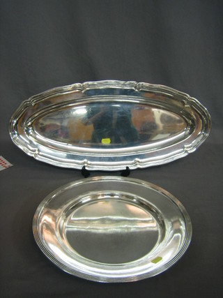An oval silver plated fish platter and a circular platter