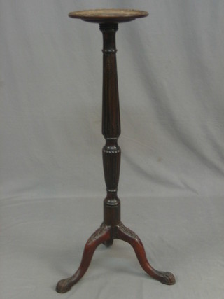 A Chippendale style turned and reeded mahogany torchere raised on tripod supports