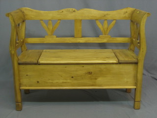 A Continental pine settle with pierced back, the seat with hinged lid 47"