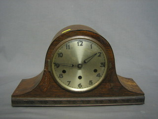 A chiming mantel clock with silvered dial contained in an oak arch shaped Admiral's hat shaped case