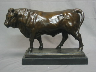 A large reproduction bronze figure of a standing bull, raised on a marble base 20"