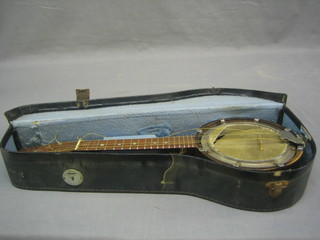 An 8 string Ukulele with 5 1/2" drum (f) contained in a fibre carrying case