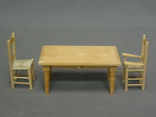 A dolls house pine framed kitchen table raised on turned supports together with a carver chair and a standard chair