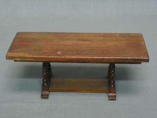 A dolls house refectory style dining table raised on turned supports with H framed stretcher 7"