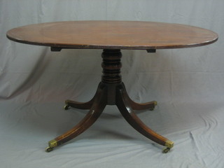 A handsome Georgian oval snap top breakfast table raised on a gun barrel column and tripod supports ending in brass caps and castors 53"