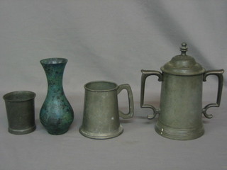 A Victorian twin handled pewter cup with glass case (f), a waisted pewter beaker, a metal club shaped vase and a pewter tankard marked 500 squadron