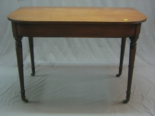 A Georgian D shaped mahogany side table raised on ring turned supports ending in brass caps and castors 42"