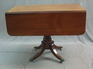 A 19th Century mahogany pedestal Pembroke table fitted a drawer, raised on a turned column and tripod base ending in brass paw feet 36"