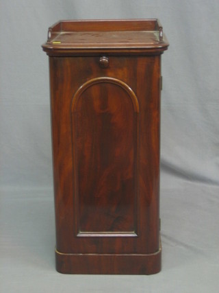 A Victorian mahogany pot cupboard with three-quarter gallery enclosed by a panelled door, raised on a platform base 16"