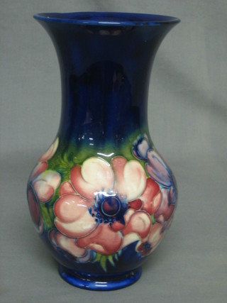 A Moorcroft blue glazed club shaped vase with anemone pattern, the base with signature mark, impressed HM Potter to The Queen 10"