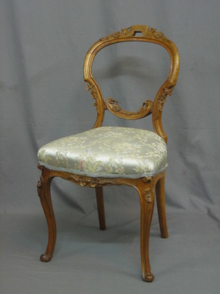 A Victorian bleached walnut balloon back dining chair with carved mid rails and upholstered seat of serpentine outline, raised on cabriole supports