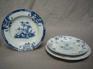 A circular blue and white Delft plate (cracked), 1 other decorated a figure and 1 other decorated a landscape (chipped) 9"