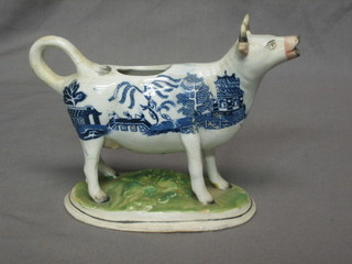 A 19th Century blue and white pottery cow creamer with Willow pattern decoration (tail f and r)