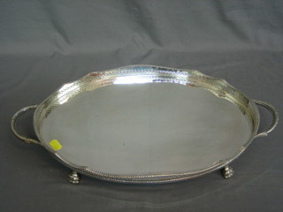 An oval silver plated twin handled tea tray, raised on 4 hoof supports 16"