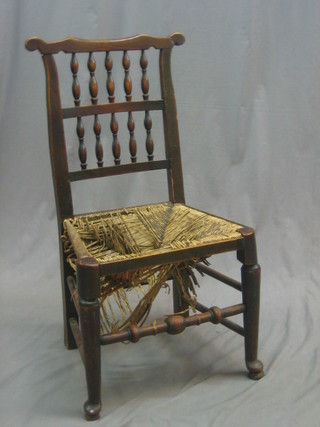 An  18th Century elm stick and rail back chair with bobbin turned decoration and woven rush seat, raised on turned supports