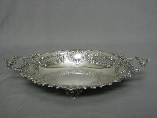 An oval Continental engraved white metal pierced twin handled bowl, raised on 4 paw supports, 20 ozs