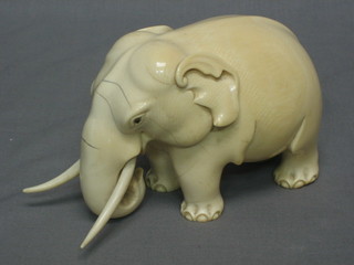 A carved ivory figure of a walking elephant 7"