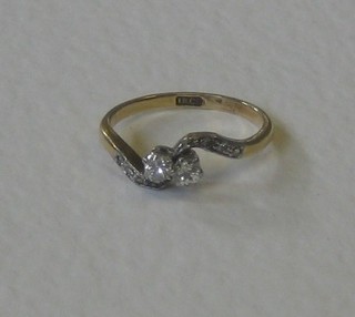 A lady's 18ct gold crossover dress ring set 2 diamonds and with 6 diamonds to the shoulders 