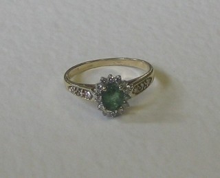 A lady's gold dress ring set an oval cut emerald surrounded by diamonds