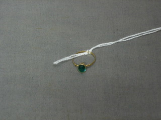 A gold ring set a green oval cut stone