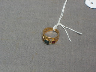 A gilt metal ring set red and green stones