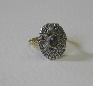 A gold dress ring set an oval cut blue stone