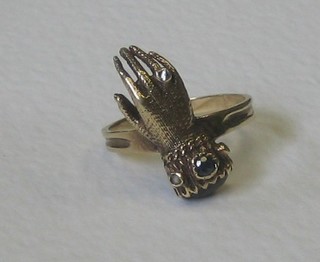 A gold dress ring in the form of a hand set diamonds