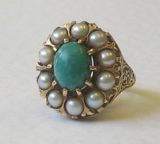 A gold dress ring set a cabouchon cut turquoise surrounded by demi-pearls