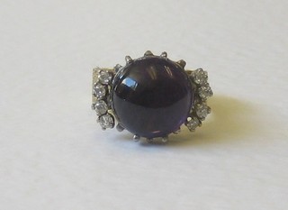 An 18ct gold dress ring a cabouchon cut amethyst  supported by 6 diamonds
