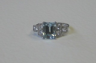 An 18ct white gold dress ring set a rectangular cut aquamarine and with 6 diamonds to the shoulders, approx 0.55/2.25ct