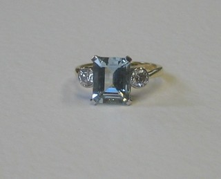 A lady's 18ct yellow gold dress ring set a rectangular cut aquamarine supported by 2 diamonds