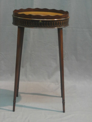 An oval mahogany Chippendale style urn table with wavy border and blind fret work frieze, raised on square tapering supports 14"