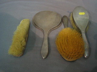 A silver backed hand mirror, 2 silver backed hair brushes and a silver backed clothes brush