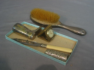 A silver backed hand mirror, a glass and silver scent bottle (f), a gilt metal travelling clock and a silver plated scoop
