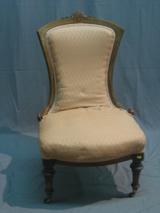 A Victorian inlaid bleached mahogany nursing chair upholstered in pink material, raised on turned supports